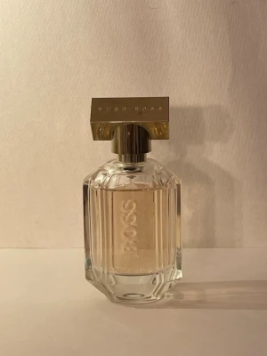 Hugo Boss the scent for her - Hugo boss the scent for her 50ml. Se bilder på noter. Doftar som den ska ,förvarad bra. Men parfumen  är flera år gammal därav priset är billigt. 