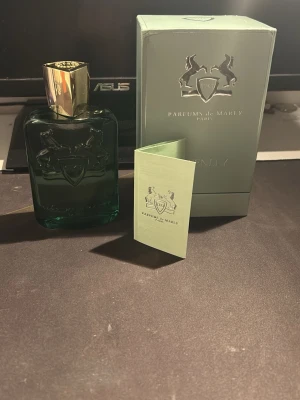 Parfums de Marly Greenley parfym typ 123 ml kvar  - Exklusiv parfym från Parfums de Marly, modellen Greenley. Flaskan är grön med elegant guldlock och har en ingraverad logotyp med två hästar. Kommer i originalkartong och med tillhörande informationshäfte. Perfekt för dig som gillar lyxiga dofter.