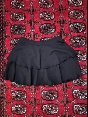 Svart volangkjol, lager 157 - Säljer en svart kortkjol från lager 157 med dubbla volanglager. Säljer då den inte kommer till användning längre ☺️
