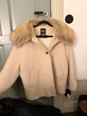 Beige kappa, äkta päls - Beige kappa från Zara med krage i äkta päls. Perfekt nu till våren 😍. Slutsåld överallt. Nypris över 3000 kr.