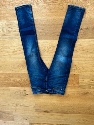 Mörkblå skinny jeans med stretch - Snygga mörkblå skinny jeans med stretch och klassisk femficksdesign. Jeansen har en lätt tvättad look och smala ben. Perfekta för en trendig och avslappnad stil. W30 L30