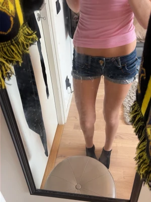 Mörkblå jeansshorts  - Snygga mörkblå jeansshorts från Fishbone med råa kanter och slitna detaljer. Klassisk femficksmodell med gylf och knapp framtill samt uppvikta benslut. Perfekta för en avslappnad och trendig look.