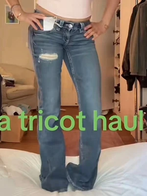 Blå bootcut jeans med slitning - Snygga blå bootcut jeans med slitning och hål på ena låret. Jeansen har klassisk femficksmodell, låg midja och ljus tvätt. Perfekta för en avslappnad och trendig look.