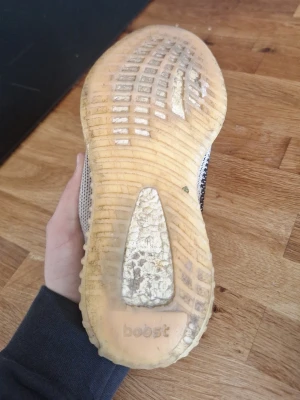Adidas Yeezy Boost 350 V2 Zebra - Säljer ett par Adidas Yeezy Boost 350 V2 Zebra med stickad ovandel i vitt, svart och röda detaljer. Sulan är i genomskinlig gummi med boost-dämpning för extra komfort. Ikonisk design med zebramönster och tight passform.