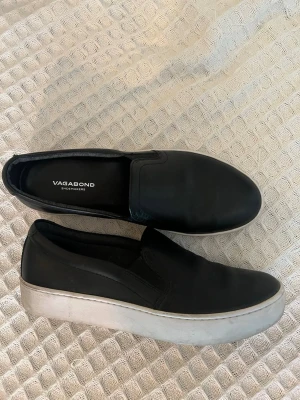 Svarta skor  - Svarta slip-on sneakers från Vagabond. Knappt använda, storlek 38.