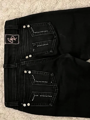 G Rise Jeans  - Snygga svarta bootcut jeans från GR med coola detaljer i form av silvriga stenar på bakfickorna. Jeansen har låg midja och klassisk femficksdesign. Materialet är stretchigt denim som sitter bekvämt och formar sig efter kroppen. Perfekta för en trendig och edgy look. Dom är utsvängda och passar mig som är ca 170 cm💕💕