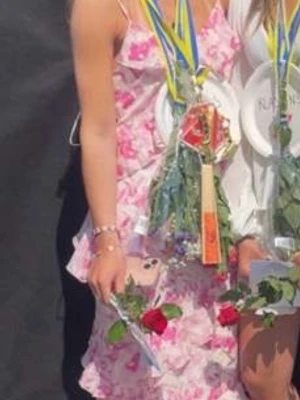 Rosa blommig volangklänning från Vila - Söt långklänning från Vila med rosa och vita blommor, tunna axelband och flera volanglager. Klänningen har en romantisk känsla och är perfekt för varma dagar. Lätt och luftig i materialet, med en feminin siluett.