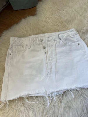 Vit jeanskjol  - Snygg vit kort jeanskjol som passar perfekt till sommaren. Jätte fint skick men det finns en liten fläck bak (se bild). Syns inte så tydligt! Super fin!🥹🥰