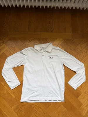 EA7 Skjorta  - Säljer en Snygg långärmad skjorta från Armani i väldigt fint skick. Texten på storlekslappen har tvättats bort men annars i väldigt fint skick. Sitter mer som en S än en M 