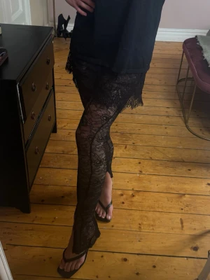 Svarta spetsleggings med blommönster - Säljer ett par svarta leggings i genomskinlig spets med blommönster. Tightsen har en tajt passform och är perfekta för att ge outfiten en extra edge. Materialet är stretchigt och bekvämt, och spetsen ger en snygg och trendig look. De har inbygga undershorts!! Älskar men för små för mig , tight