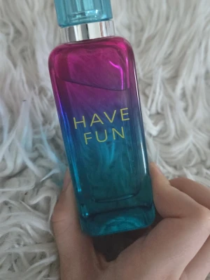 La Rive Have Fun parfym 90ml - La Rive Have Fun är en parfym i en snygg flaska med färgskiftning från rosa till blått och texten 'HAVE FUN' på framsidan. 90 ml. Förpackningen har en färgglad design med popkonst-inspirerat motiv. Perfekt för dig som gillar lekfulla och fräscha dofter. Använd max 2 gng. Lite stark för min smak men tror nog den kommer passa någon annan bättre🫶🏻. Slutsåld på H&Ms hemsida.