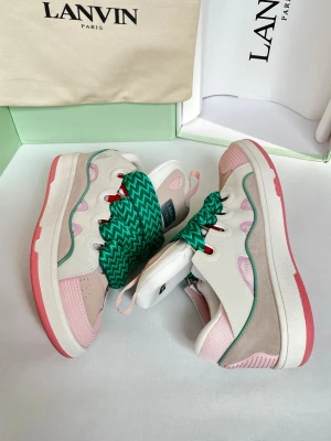 Lanvin sneakers i pastellfärger - Lanvin sneakers med chunky sula i vitt, rosa och beige. Ovandel i läder och mocka med gröna och vita breda snören, rosa detaljer och vågformad grön kant. Snygg kontrast mellan färgerna och cool design som sticker ut.
