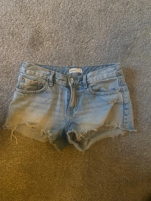 Low waist blå jeans shorts Gina tricot - Blå Low waist jeans shorts från Gina tricot, säljer för de blivit för små. Storlek 34, använt men inte slitna, bra skick