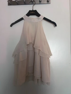 Jättefin halterneck blus - Jättefin beige/vit blus som endast har använts 2 gånger. Perfekt nu till sommaren och funkar till nästan allt. Säljer för att de inte riktigt är min stil och den inte kommer till användning 