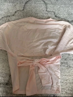 Rosa topp - Jättefin rosa topp med öppen rygg och knyt bak. Köpt på Plick och har ej använt den, så i bra skick.