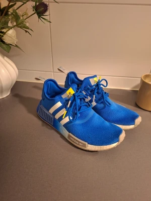 Adidas NMD R1 BlueBird - Säljer ett par NMD R1 Blue Bird som är använda 2–3 ggr, alltså väldigt fint skick. Självklart äkta. Storlek 41 1/3