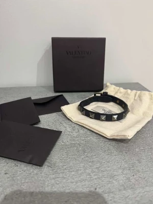 Valentino armband - Marinblå valentino armband till salu, 7/10 skick. Det är unisex, passar allihopa, då de går att justera storleken. Den är såklart äkta, men jag har tyvärr inget kvitto kvar.  Allt på bilderna medföljer. Ni kan se skadorna på armbandet, den har inga allvarliga skador, alltså inget som märks när du väl har på dig armbandet. Riktigt fin, rekommenderar starkt!