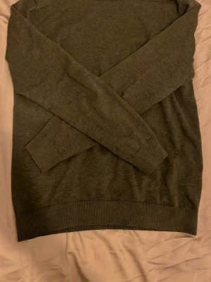 Olivgrön bläck tröja  - En enkel och stilren olivgrön stickad tröja med rund hals och långa ärmar. Tröjan har ribbade muddar vid ärmslut och nederkant. Perfekt basplagg i garderoben och passar till det mesta. Materialet känns mjukt och bekvämt. Tröjan är från bläck och är i ett fint skick utan några defekter ny pris 599 mitt pris 250