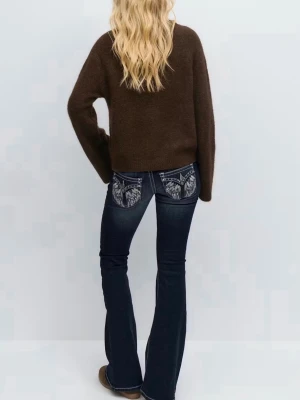 Låga bootcut jeans - Säljer ett par mörkblå bootcut jeans med kontrastsömmar och snygg broderad detalj på bakfickorna. Jeansen har låg midja och utsvängda ben, vilket ger en retrovibe. Perfekta för dig som vill sticka ut lite extra med coola detaljer.