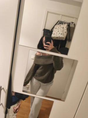 Mysig off shoulder loungewear-set - Säljer ett loungewear-set med en mörkgrön off shoulder-tröja i mjukt, stickat material och ljusgrå, vida mjukisbyxor. Perfekt för chill dagar hemma och riktigt bekväm passform. Tröjan har bred krage och byxorna har resår i midjan.