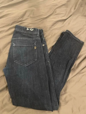 Dondup jeans - Mörkblåa Dondup George jeans med klassisk femficksdesign och diskret D-detalj på bakfickan. Jeansen har en smal passform och är tillverkade i ett mjukt denimtyg som sitter bekvämt hela dagen. Finns inga defekter. Kom med frågor o prisförslag om ni har