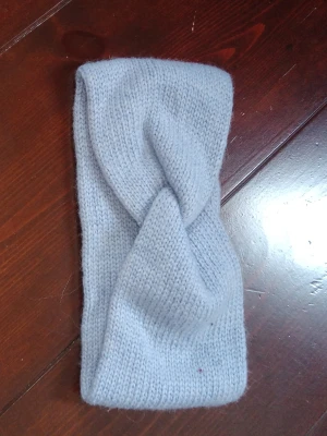 Ljusgrå stickad twistad hårband - Säljer ett snyggt ljusgrått stickat hårband med twistad detalj framtill. Perfekt för att hålla håret på plats och ge en chill vibe till din look. Mjuk och stretchig kvalitet som känns skön mot huden.