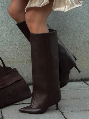 Bruna höga stövlar med klack - Snygga knähöga stövlar i mörkbrunt skinn med spetsig tå och smal klack. Stövlarna har en stilren design och är perfekta för att lyfta vilken outfit som helst. Materialet är slätt och ger en lyxig känsla. Från NAKD i bra skick men är lite sönder se sista bilden men annars väldigt fint skick! Nypris låg på över 1000kr