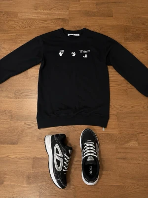 Svart sweatshirt från Offwhite och B30 - Cool svart sweatshirt från Off-White med vita tryckdetaljer framtill och ett stort blått och vitt grafiskt tryck på ryggen. Skorna har passform 44 priset kan diskuteras