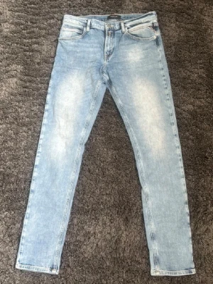 Ljusblå Replay jeans - Säljer ett par ljusblå Replay slim jeans med klassisk femficksdesign. Jeansen har normal midja, dragkedjegylf och raka ben. Tillverkade i bomull med en skön stretch för extra komfort. W30 och L32