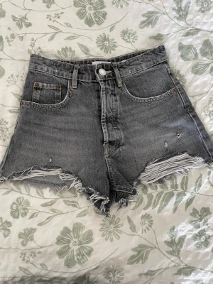 Gråa högmidjade jeansshorts - Gråa högmidjade jeansshorts. Från Zara i storlek 34, mycket bra skick.