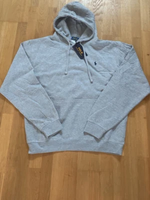 Grå Ralph Lauren Hoodie Storlek L - Den är i storlek M men är väldigt stor skulle säga att den passar en stor M eller en L den är helt ny med prislapp kvar säljer för att den var för stor på mig hör av er vid funderingar pris kan diskuteras vid snabb affär😁