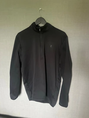 Svart halvzip tröja från Under Armour - Svart Under Armour half zip träningströja passar M/L