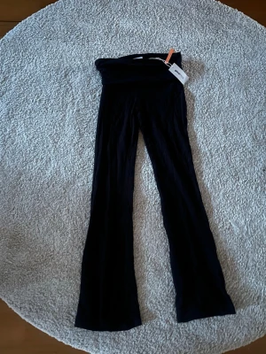 Svarta low waist leggings från Gina Tricot - Säljer ett par svarta low waist leggings från Gina Tricot med utsvängda ben.  Stretchigt material som sitter snyggt och bekvämt. Perfekta att styla med en oversized hoodie, crop top eller bara ha hemma