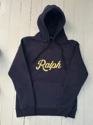 Ralph Lauren hoodie storlek S - Hej! Säljer denna riktigt schyssta hoodie från Ralph Lauren. Den är i storlek M men sitter en storlek litet och passar därför som en S. Den är endast använd någon enstaka gång och är därmed i ett nyskick (om den ser fläckig/solblekt ut är det endast pga dåligt fotoljus). Original lappar och påse finns kvar och medföljer naturligtvis vid köp. Jag fraktar alltid snabbt! Mvh