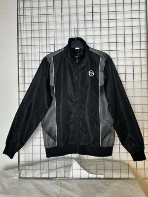 Trackjacka Sergio Tacchini - Denna vara kommer att auktioneras ut på på Humana x Plick Live den 8 juni klockan 19:30