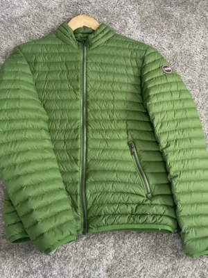 Grön pufferjacka från Colmar 16 år - Säljer en snygg grön pufferjacka storlek XS-S 16 år från Colmar med quiltad design och diskret logotyp på ärmen. Jackan har dragkedja framtill, två sidofickor med dragkedja och står upp-krage. Perfekt för kalla dagar och riktigt lätt att bära.