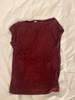 Mörkröd enkel topp - En basic mörkröd topp med korta ärmar och rund halsringning. Toppen har en rak passform och är tillverkad i ett mjukt, tunt material som känns skönt mot huden. 