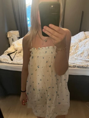 Vit blommig klänning - Säljes för den knappt används, super fin och skön.