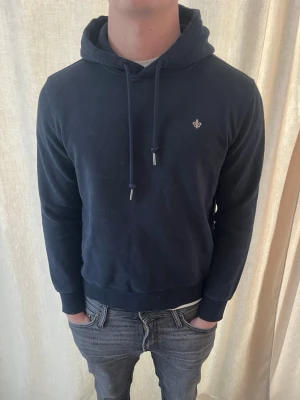 Mörkblå hoodie från Morris  - Otroligt snygg hoodie från Morris. Mycket bra skick. Strl M, personen på bilden är 184 cm lång. Skicka gärna prisförslag. Kika in min profil för liknande plagg.