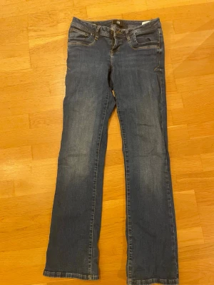 Blå bootcut jeans från LTB - Snygga blå bootcut jeans från LTB. Jeansen har normal midja och är tillverkade i mjukt denimtyg med lite stretch för skön passform. Perfekta för en avslappnad och trendig look. 27/32
