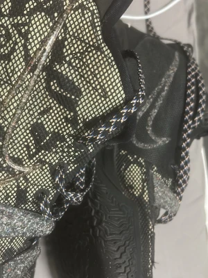 Nike Kyrie mönstrade sneakers - Säljer ett par Nike Kyrie sneakers med svart och beige mesh-överdel, coolt grafiskt mönster och reflekterande detaljer. Skorna har svarta och vita mönstrade skosnören, samt en robust svart sula. Perfekta för dig som gillar unika och sportiga sneakers.