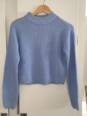 Ljusblå stickad tröja med hög krage - Säljer en ljusblå stickad tröja i storlek XS för 100kr
