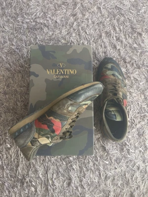 Valentino rockrunners - Snygga sneakers från Valentino Garavani med camomönster i grönt, svart, beige och rött. Skorna har lågt skaft och är tillverkade i en mix av mocka, läder och textil. Sulan är i gummi och har tydlig struktur.