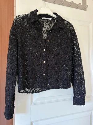 Svart spets skjorta  - En svart spets skjorta med silver giltter ifrån Zara 