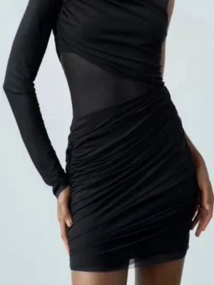 Zara svart mesh one shoulder klänning - Aldrig använd kort svart klänning i mesh med one shoulder-design och lång ärm. Klänning har ickså meshdeyalj vid magen. Köpt för 399kr, prislappen sitter kvar