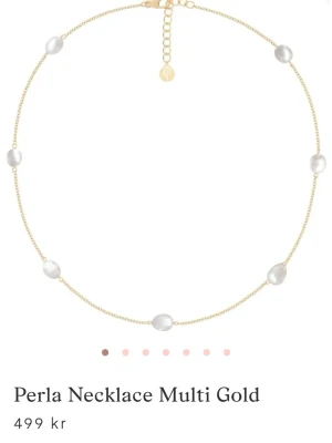 Edblad pärl halsband - Ett elegant halsband i guldton med flera vita pärlor jämnt fördelade längs den tunna kedjan. Perfekt för dig som gillar stilrena och trendiga accessoarer. Justerbar längd med liten logoberlock vid låset.