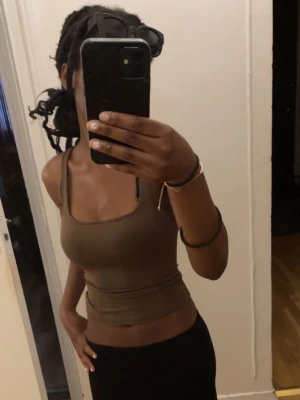 Brun croppad linnetopp - Snygg brun croppad linnetopp med smala axelband. Perfekt för varma dagar eller att styla lager på lager, funkar för dig som har Xs eller xxs. Enkel och stilren design som passar till det mesta💓