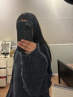 Mörkgrå oversized stickad tröja - En riktigt mysig och oversized stickad tröja i mörkgrå färg. Tröjan har breda ärmar och ett ribbstickat mönster som ger en cool och avslappnad look. Perfekt för att hålla sig varm och ändå se stylish ut under kalla dagar.