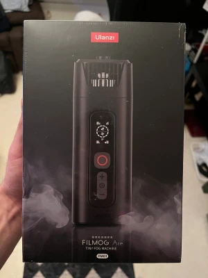 Ulanzi FILMOG Ace rökmaskin - Säljer en Ulanzi FILMOG Ace Tiny Fog Machine, perfekt för att skapa rökeffekter till foto och video. Den är svart, kompakt och har digital display med flera inställningar för intensitet och hastighet. Smidig att ta med och enkel att använda för kreativa projekt.