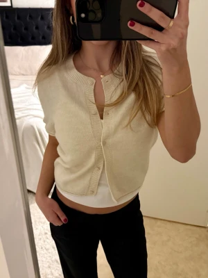 Beige kortärmad kofta - Säljer en beige kortärmad kofta från H&M i storlek M. Jättefint skick!